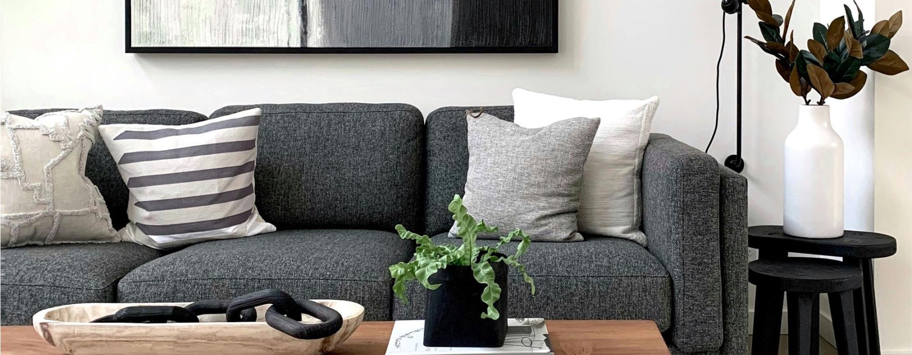 a couch with a coffee table with a plant and decor on it